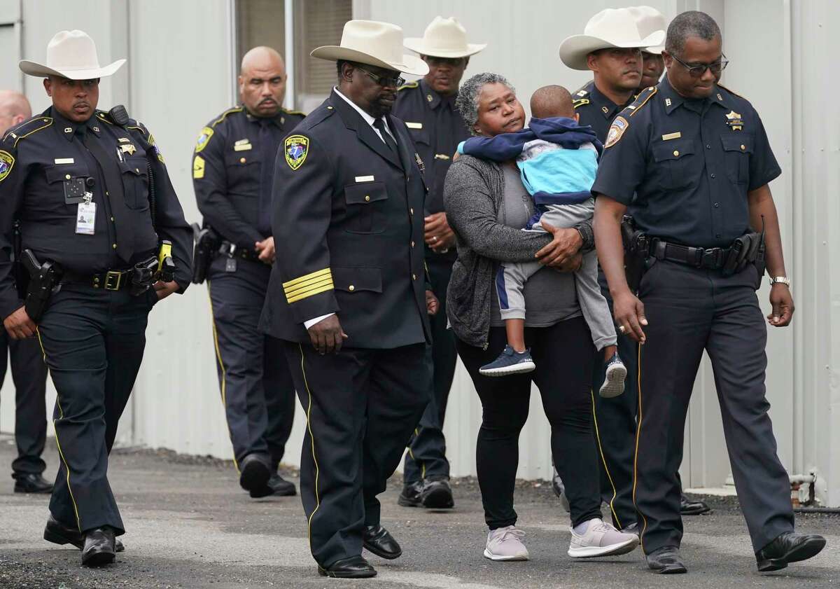Tanya Childress, mother of fallen Harris County Precinct 7 Deputy Constable Deputy Jennifer Chavis, carries her grandson, Billion Chavis, 4, the son Constable Deputy Chavis, as they leave from the Claire Brothers Funeral Home, 5525 Pine St., after a procession from Harris County Institute of Forensic Sciences Tuesday, April 5, 2022, in Houston. She was killed in a fiery crash caused by a suspected drunk driver on April 2.