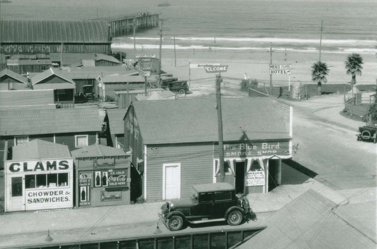 Buildings in Pismo Beach in this undated historical photograph include a clam stand and smoke shop, with the beach in the background.
