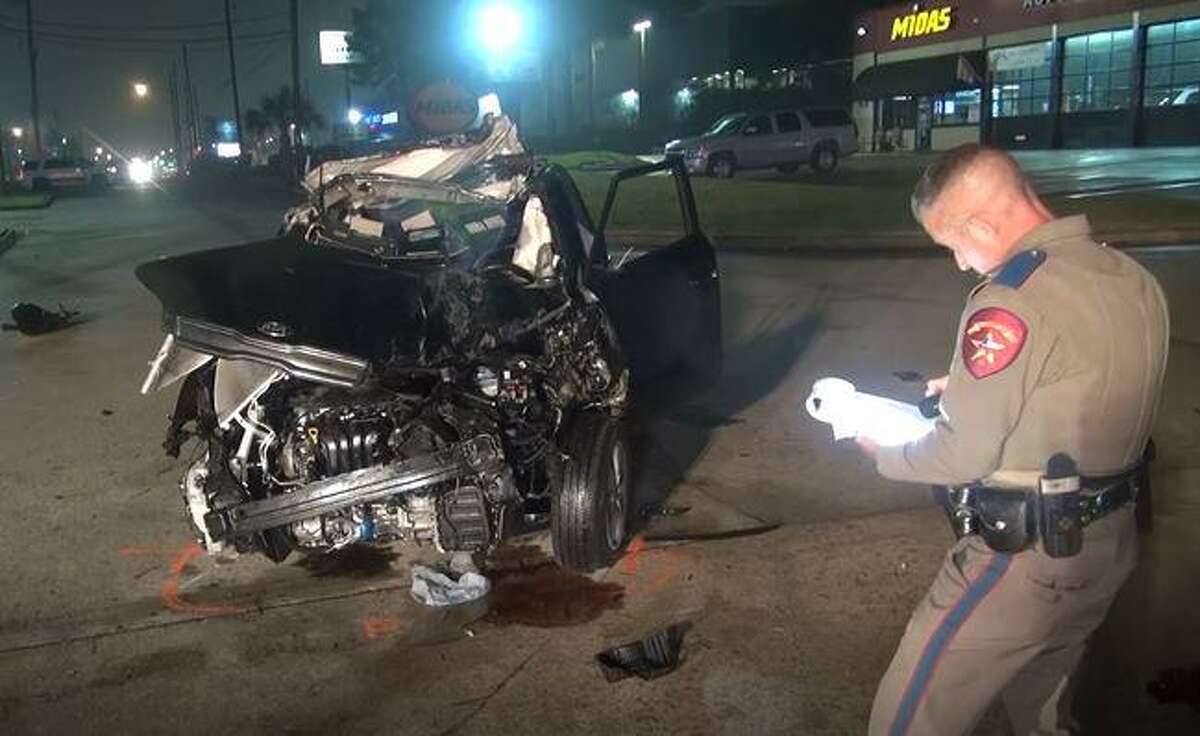 A Kia Sol is seen following a crash where its driver was pronounced dead on the scene Monday night in Spring. A Texas Department of Public Safety trooper is seen beside the damage.