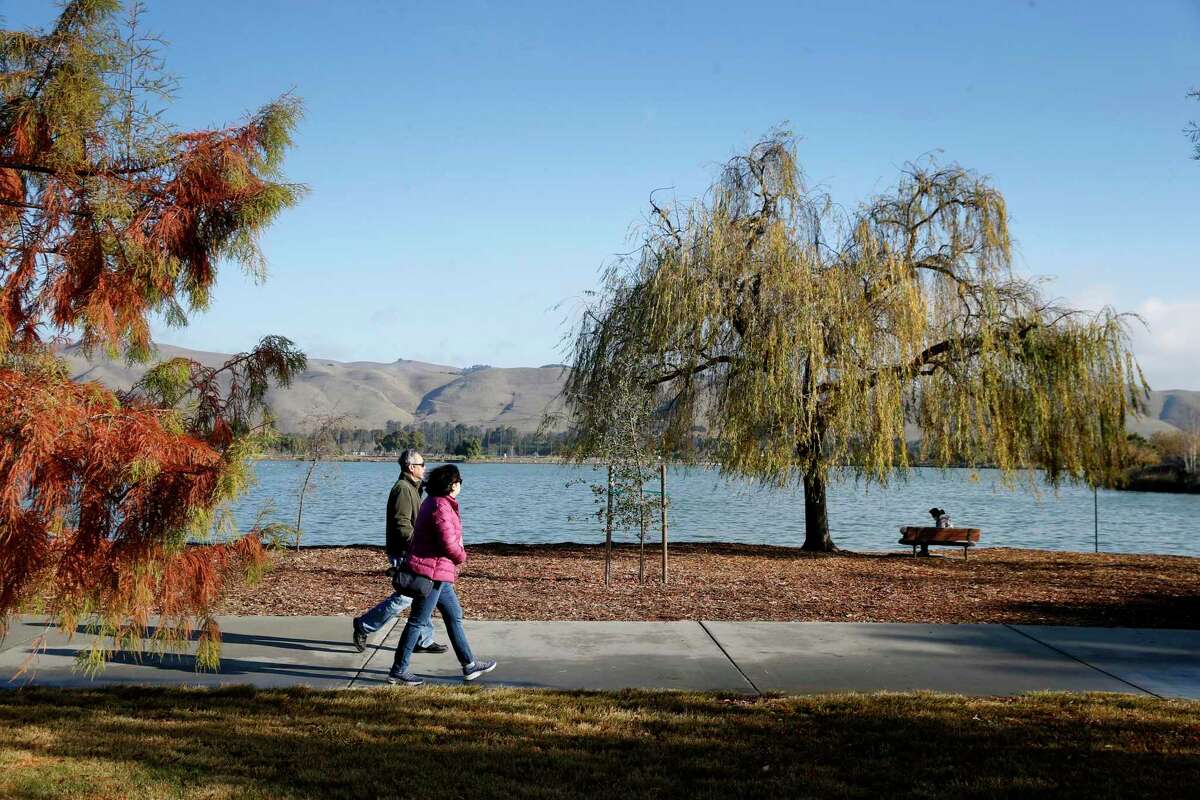 Visitors take a lap around Lake Elizabeth between rainstorms at Central Park in Fremont, California.