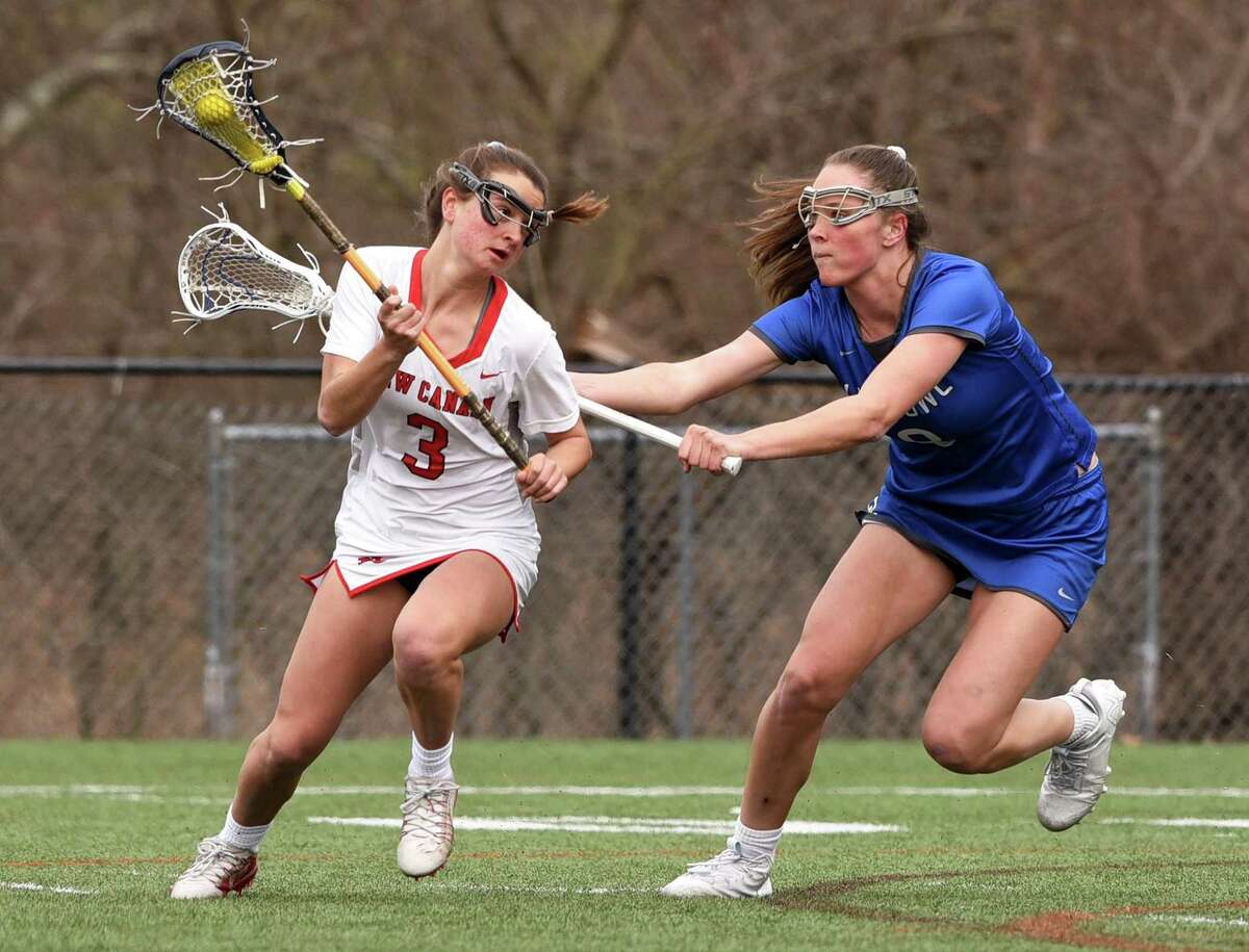 New Canaan's Dillyn Patten (3) on the attack while Ludlowe's Kaleigh Sommers (8) defends during a girls lacrosse game in New Canaan on Tuesday, April 5, 2022.
