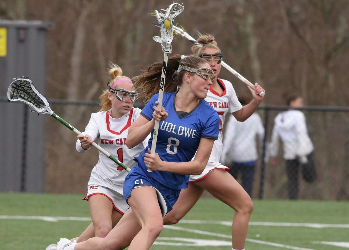 Ludlowe’s Kaleigh Sommers (8) looks for a shot while New Canaan’s Carolyn Baran (1) and Stella Nolan (5) defend on Tuesday.