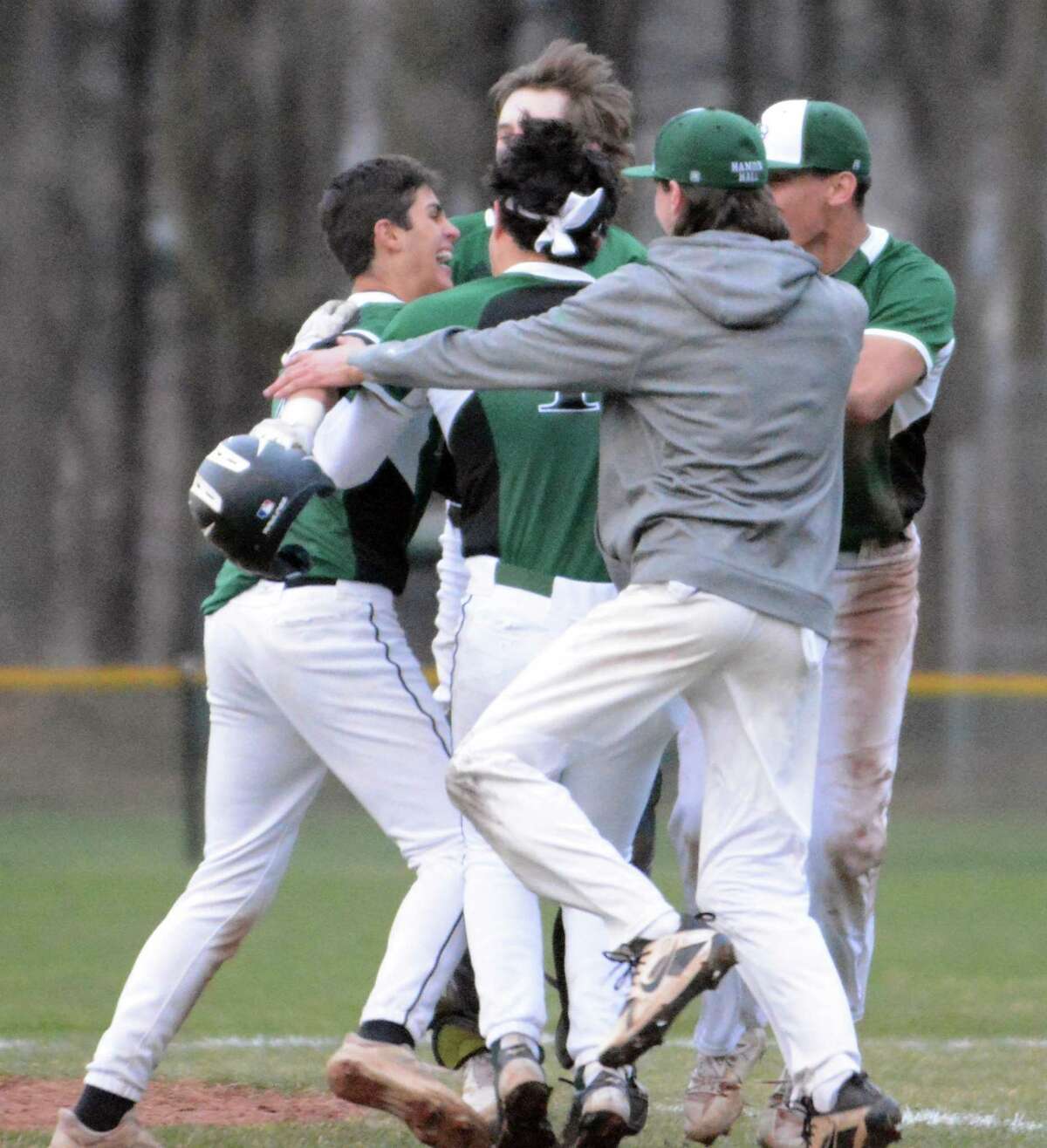 Bennett Crerar, far left, is mobbed at second base after hitting the winning single for Hamden Hall in a 9-8 victory over Hopkins on Tuesday.