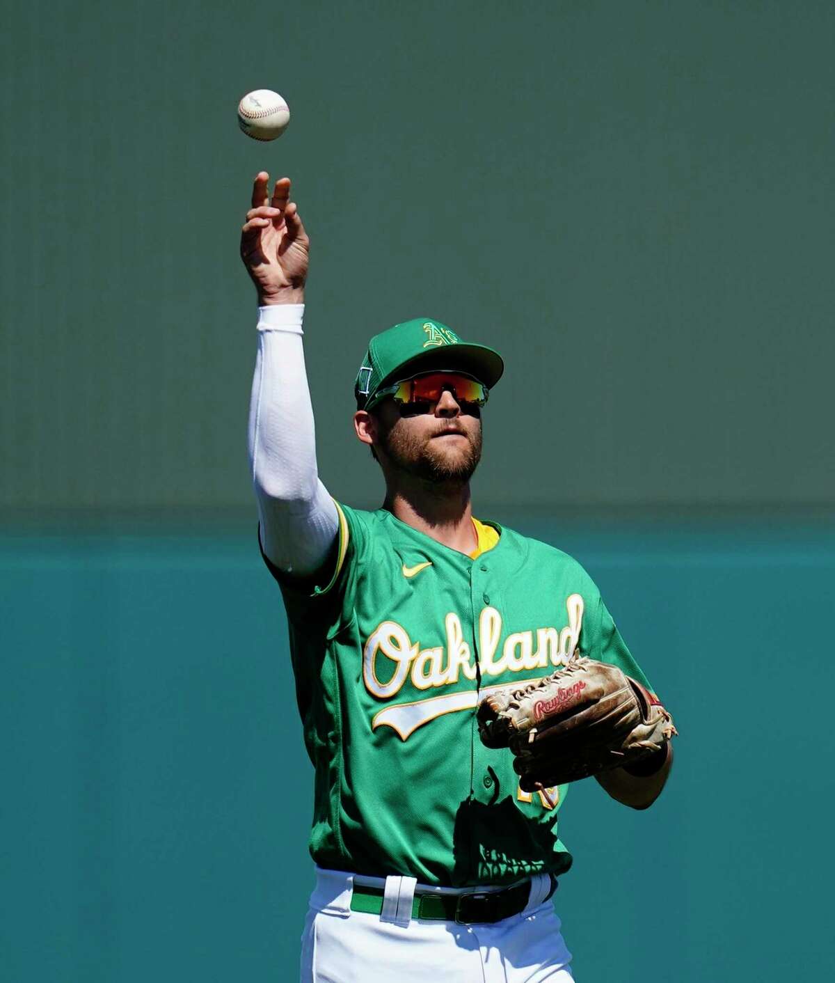 Oakland Athletics left fielder Chad Pinder tosses the ball back to the infield during the third inning of a spring training baseball game against the Colorado Rockies Saturday, April 2, 2022, in Mesa, Ariz. (AP Photo/Ross D. Franklin)