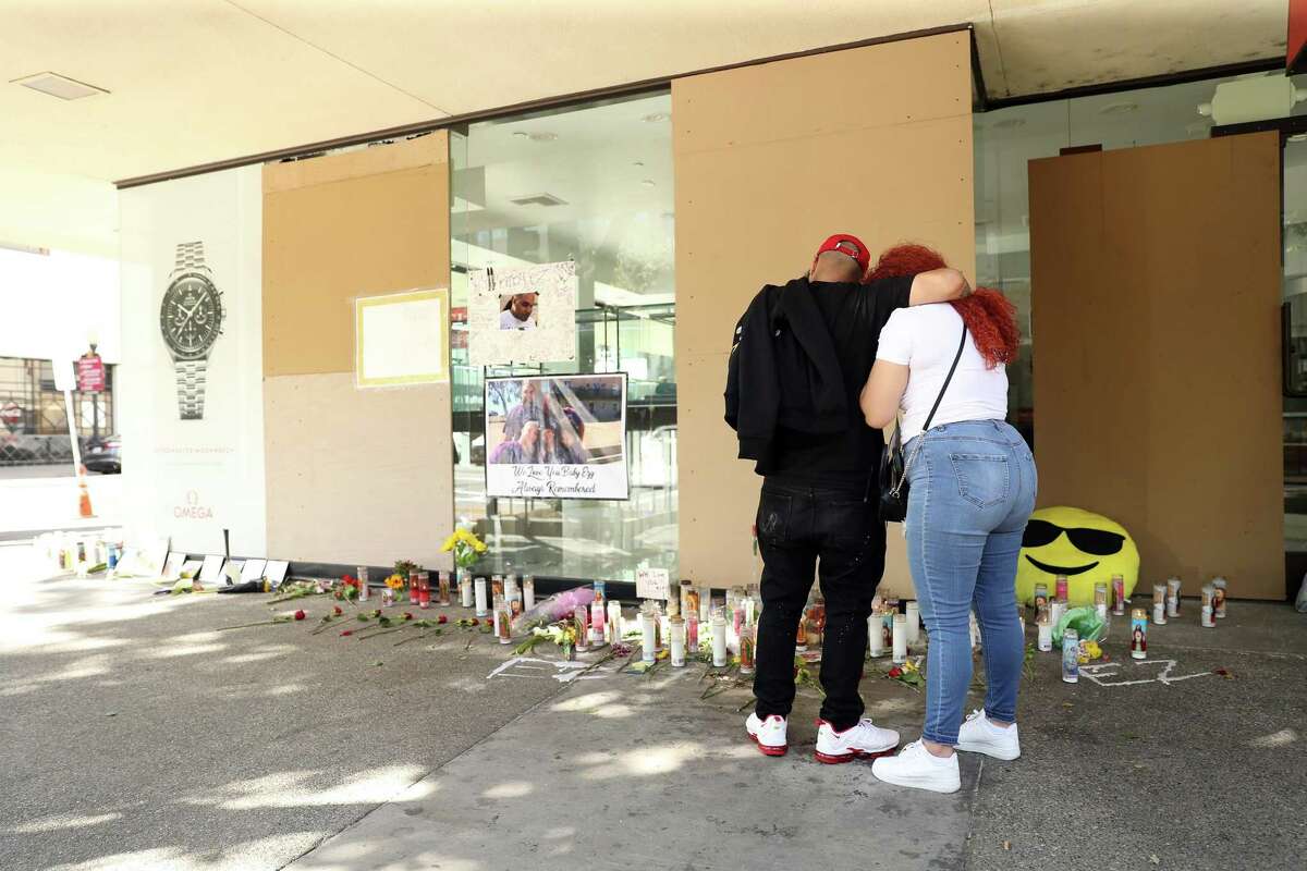 In the aftermath of last weekend’s mass shooting that killed 6 people, Xander Simpson and Britonnie Cooper, cousins of victim Devazia Turner, console each other at the scene of Turner’s death at 10th and K in Sacramento, Calif., on Tuesday, April 5, 2022.