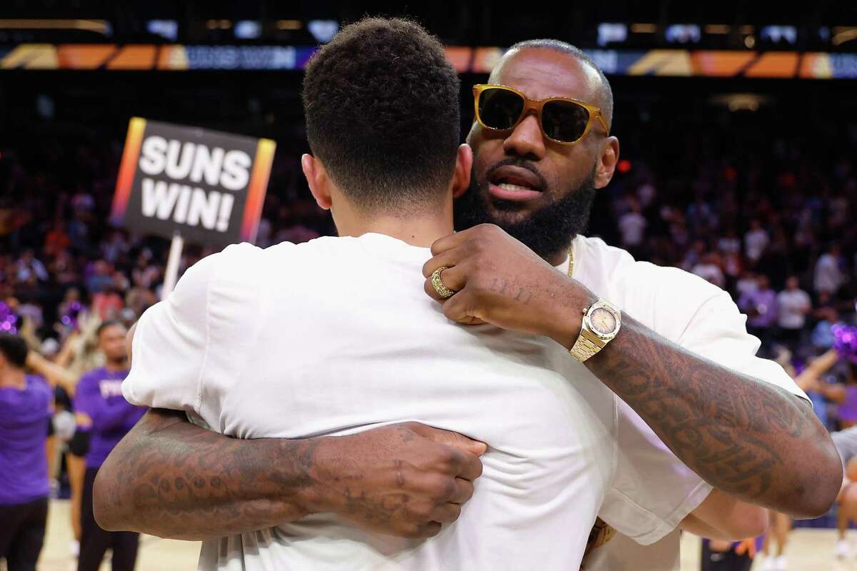 PHOENIX, ARIZONA - APRIL 05: LeBron James #6 of the Los Angeles Lakers hugs Devin Booker #1 of the Phoenix Suns following the NBA game at Footprint Center on April 05, 2022 in Phoenix, Arizona. The Suns defeated the Lakers 121-110. NOTE TO USER: User expressly acknowledges and agrees that, by downloading and or using this photograph, User is consenting to the terms and conditions of the Getty Images License Agreement. (Photo by Christian Petersen/Getty Images)