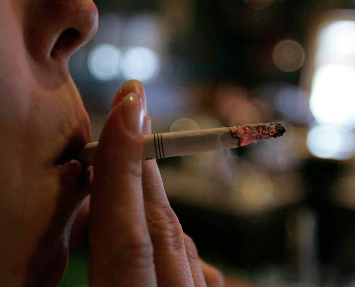 FILE - In this Tuesday, June 3, 2008 file photo, an employee smokes a cigarette at a bar and restaurant in Harrisburg, Pa. In a study released Wednesday, May 13, 2015, smokers with $150 of their own money at stake were far more likely to quit than smokers who didn’t have to wager their money to get cash rewards. "A bit of a stick was much better than pure carrot," said the study's lead author, Dr. Scott Halpern of the University of Pennsylvania. But here’s the catch: Few people were willing to bet on themselves. Nearly everyone who was offered the rewards-only option, though, signed up for a stop smoking program. (AP Photo/Carolyn Kaster)