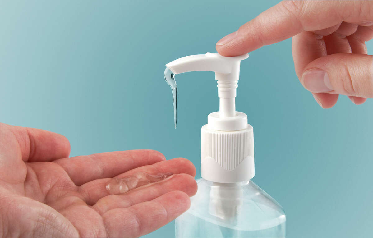 Pumping hand sanitizer into hand.