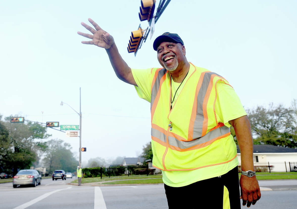 Marshall Middle School crossing guard Larry Payne smiles and waves non-stop as co-worker Bobby Frank does the same from his corner of Dowlen and Westgate before the start of school last month. Photo made Monday, March 28, 2022 Kim Brent/The Enterprise