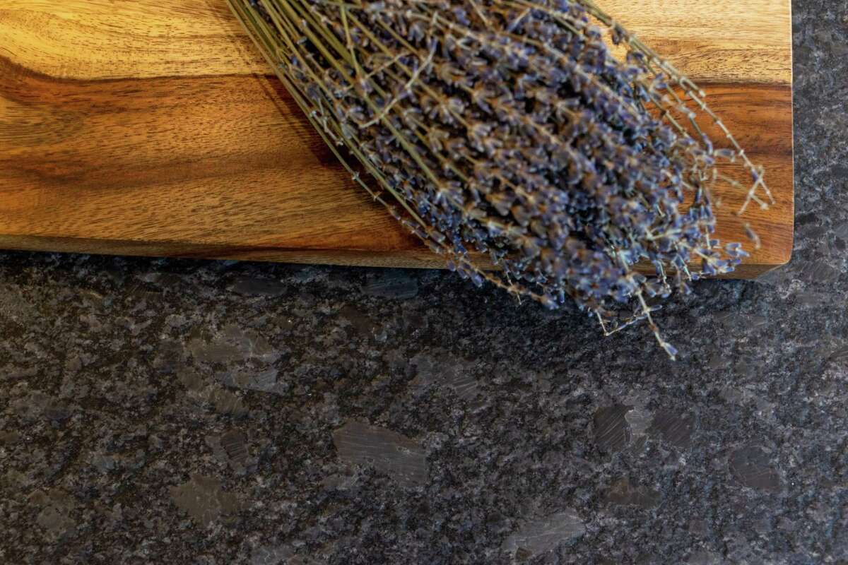 Les comptoirs en carreaux ont été remplacés par du granit foncé et cuiré au fini mat, pour mieux cacher la saleté et s'intégrer au reste de l'esthétique de la cuisine.