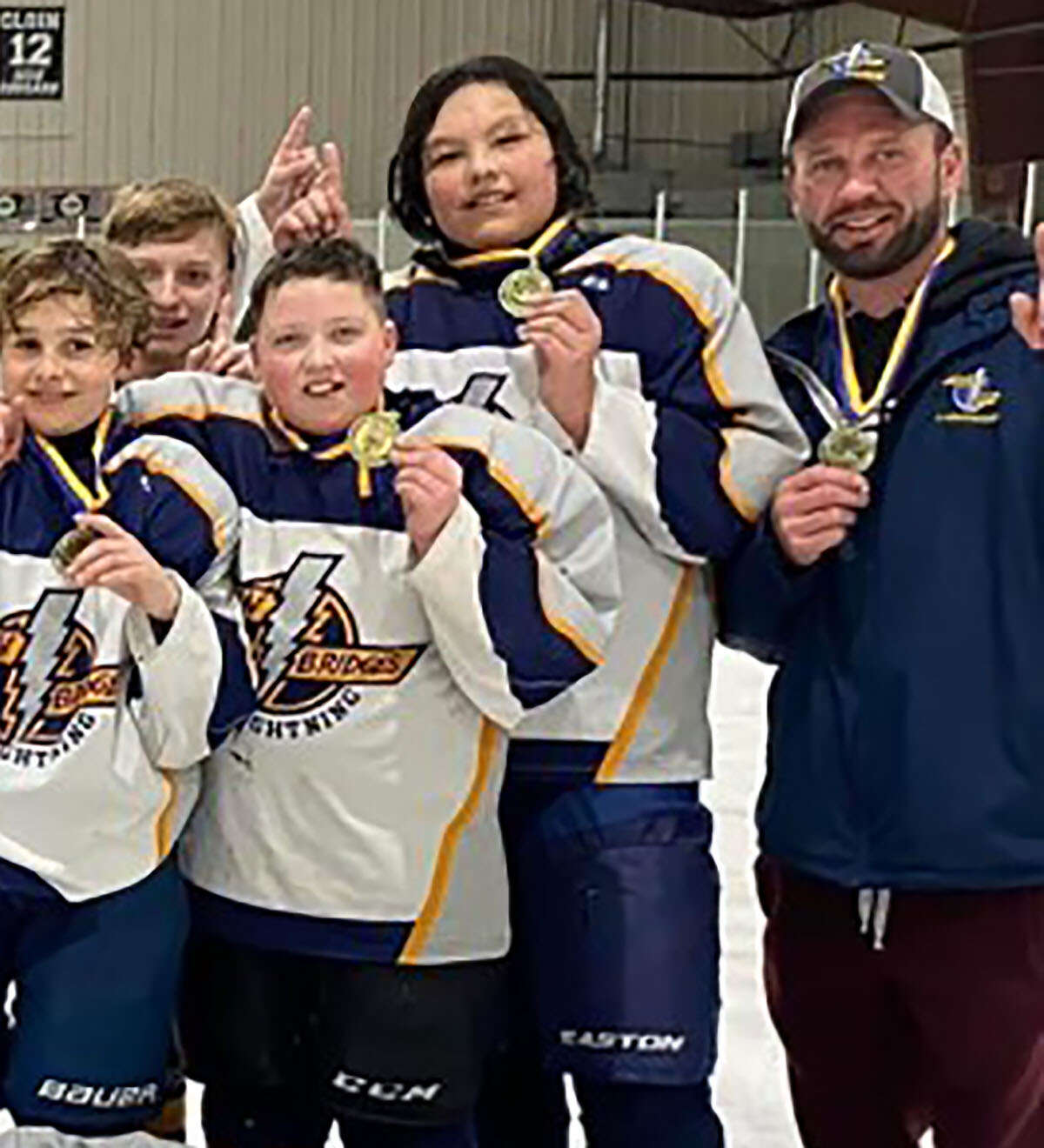 James Mitchell, fsr right, celebrates with a Twin Bridges Lightning club team after winning a tournament last season. Mitchell has been named the next head coach of the East Alton-Wood River High Oilers hockey team of the Mississippi Valley Club Hockey Association.