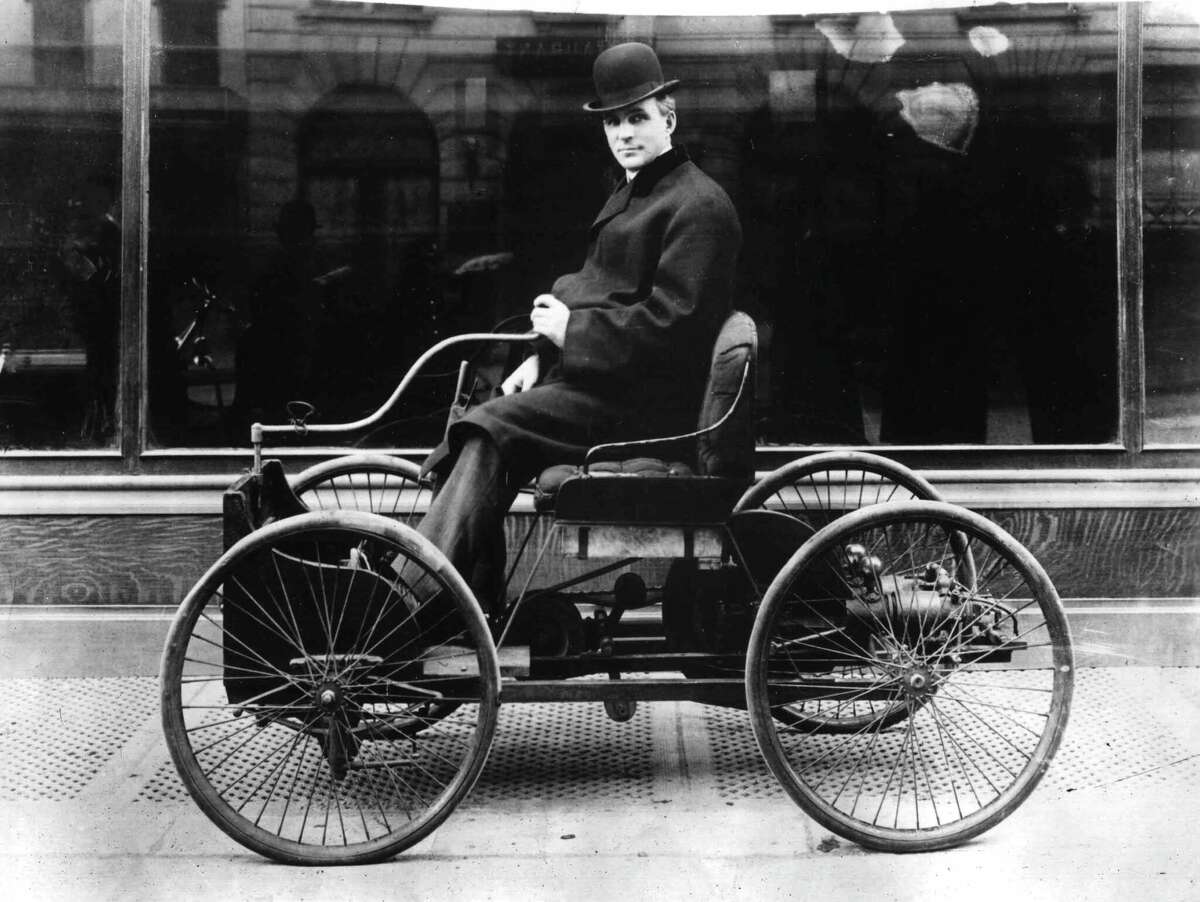American inventor and industrialist, Henry Ford poses in the driving seat of his first car, the Quadricycle, in New York City, in 1910.