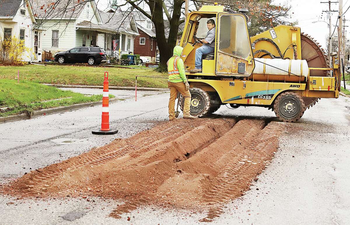 John Badman|The Telegraph Employees of Kinney Contractors, Inc., in Raymond used special saw trucks with blades as big as a man Wednesday to cut through the pre-marked bad patches of Brown Street in Alton from Main Street to Worden Street. 