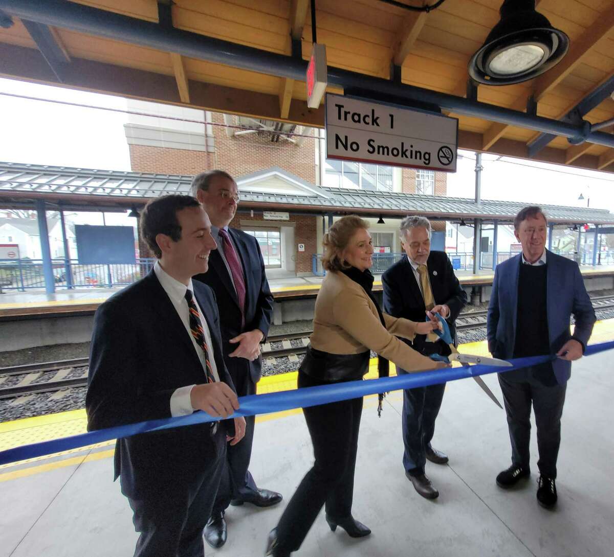 Gov. Ned Lamont, right, and Transportation Commissioner Joseph Giulietti, second from right, celebrate the unveiling of a newly renovated Shore Line East train station in Clinton on April 6, 2022, with and state Sen. Will Haskell, left, and others.