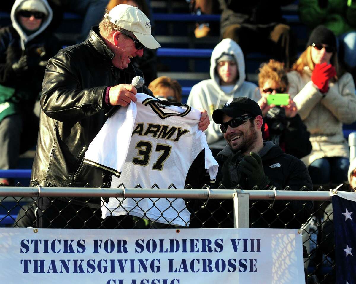West Point lacrosse coach Jack Emmer presents US Army Captain Benjamin Harrow with his old Army jersey, during the 8th Annual Sticks for Soldiers 2013 Thanksgiving Lacrosse Classic at Ludlowe’s Taft Field.