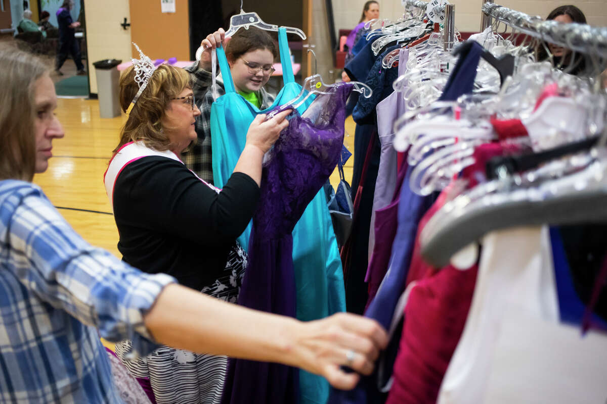 Volunteer Lisa Miner, second from left, assists Kurstin Mead, 17, in selecting dresses to try on during the "Share Your Memories" event, which provides free formal dresses to local girls, Wednesday, April 6, 2022 at Greater Midland North Family Center.