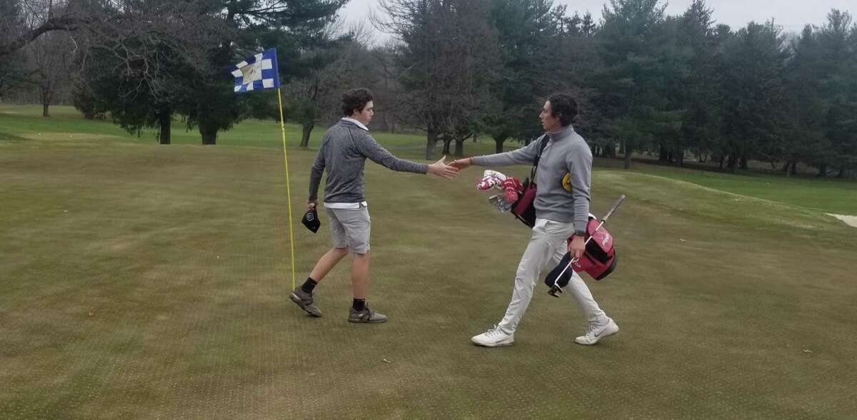 Amity's Brett Chodos (left) shakes hands with Hamden hall golfer Ben James following their nine-hole round at The Tradition Golf Club at Oak Lane in Woodbridge on March 31, 2022.