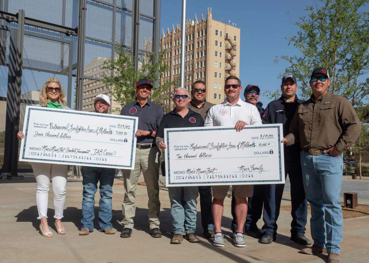 Wes and Allison Webb present a check for $10,000 to Professional Firefighters Association of Midland 04/07/2022 as part of their money raised during the March 19th Mac's MusicFest in downtown Midland. Tim Fischer/Reporter-Telegram