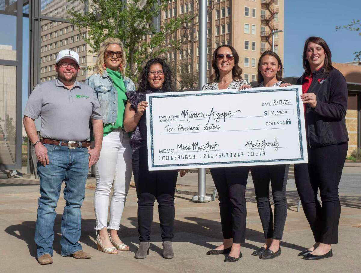 Wes and Allison Webb present a check for $10,000 to Mission Agape 04/07/2022 as part of their money raised during the March 19th Mac's MusicFest in downtown Midland. Tim Fischer/Reporter-Telegram