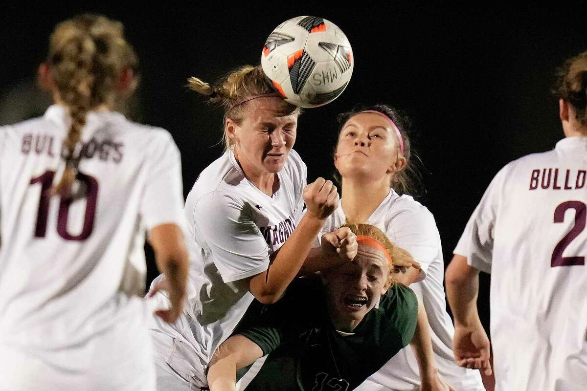 Magnolia’s Rylie Pierce, back left, heads the ball as Kingwood Park’s Emma Yeager defends during the first half of a Region III-5A quarterfinal high school soccer playoff game, Friday, April 1, 2022, in Humble.