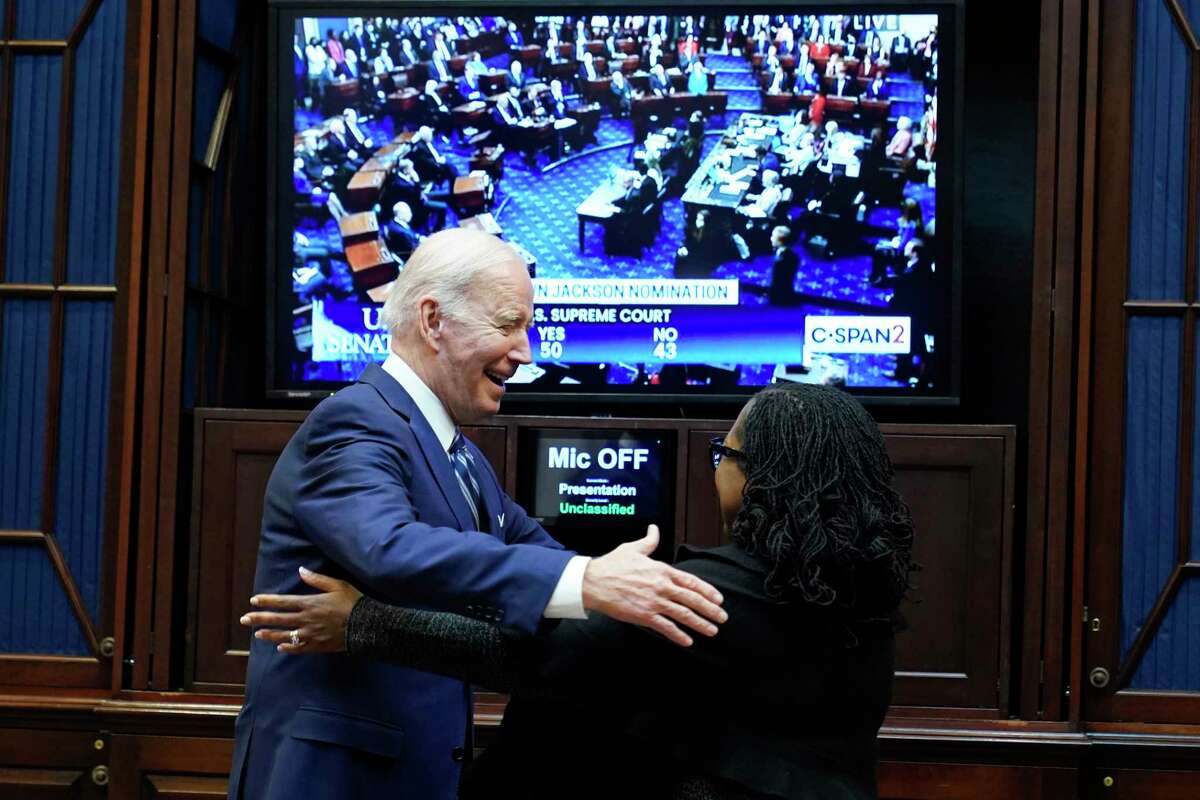 President Joe Biden goes to hug Supreme Court nominee Judge Ketanji Brown Jackson as they watch the Senate vote on her confirmation from the Roosevelt Room of the White House in Washington, Thursday, April 7, 2022.