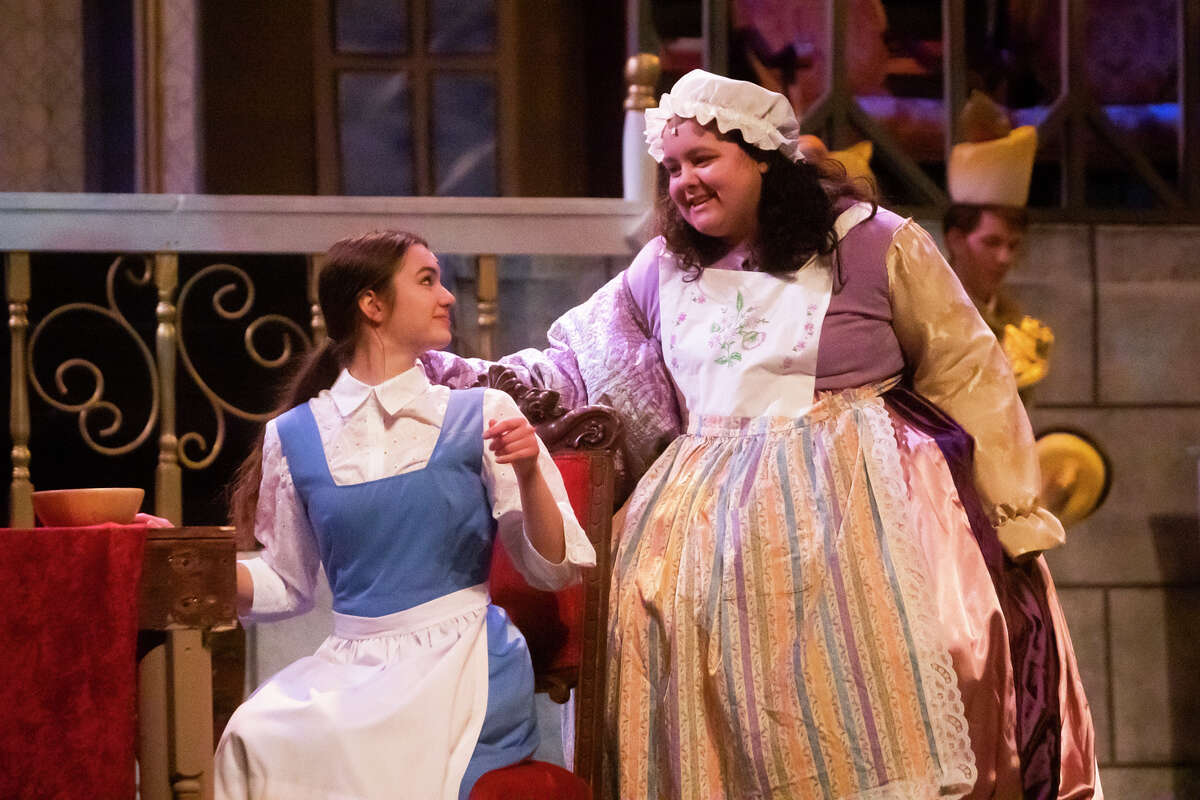 Lilly Kyro in the role of Mrs. Potts, right, and Chloe Vandenbossche in the role of Belle, left, rehearse a scene during a dress rehearsal for Midland High School's production of "Beauty and the Beast" Wednesday, April 6, 2022 at Central Auditorium.