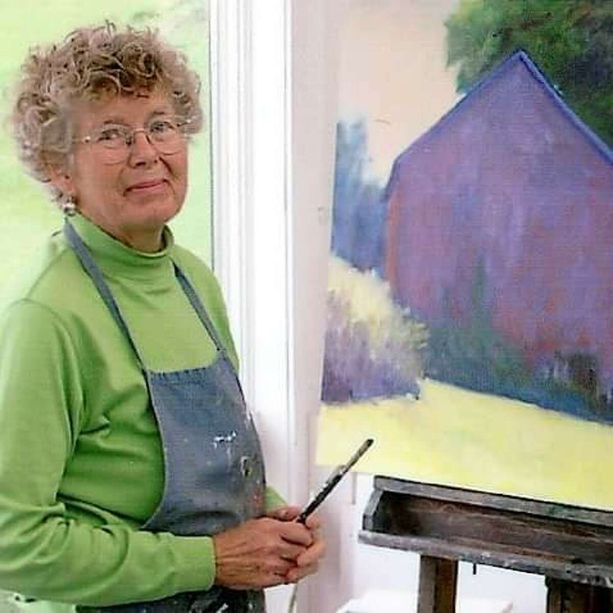Virginia “Jini” McNeice, a well-known landscape artist in the Capital Region, is photographed beside one of her paintings. Her family is holding a sale of her artwork, with over 200 pieces in her collection, following her passing in 2019.
