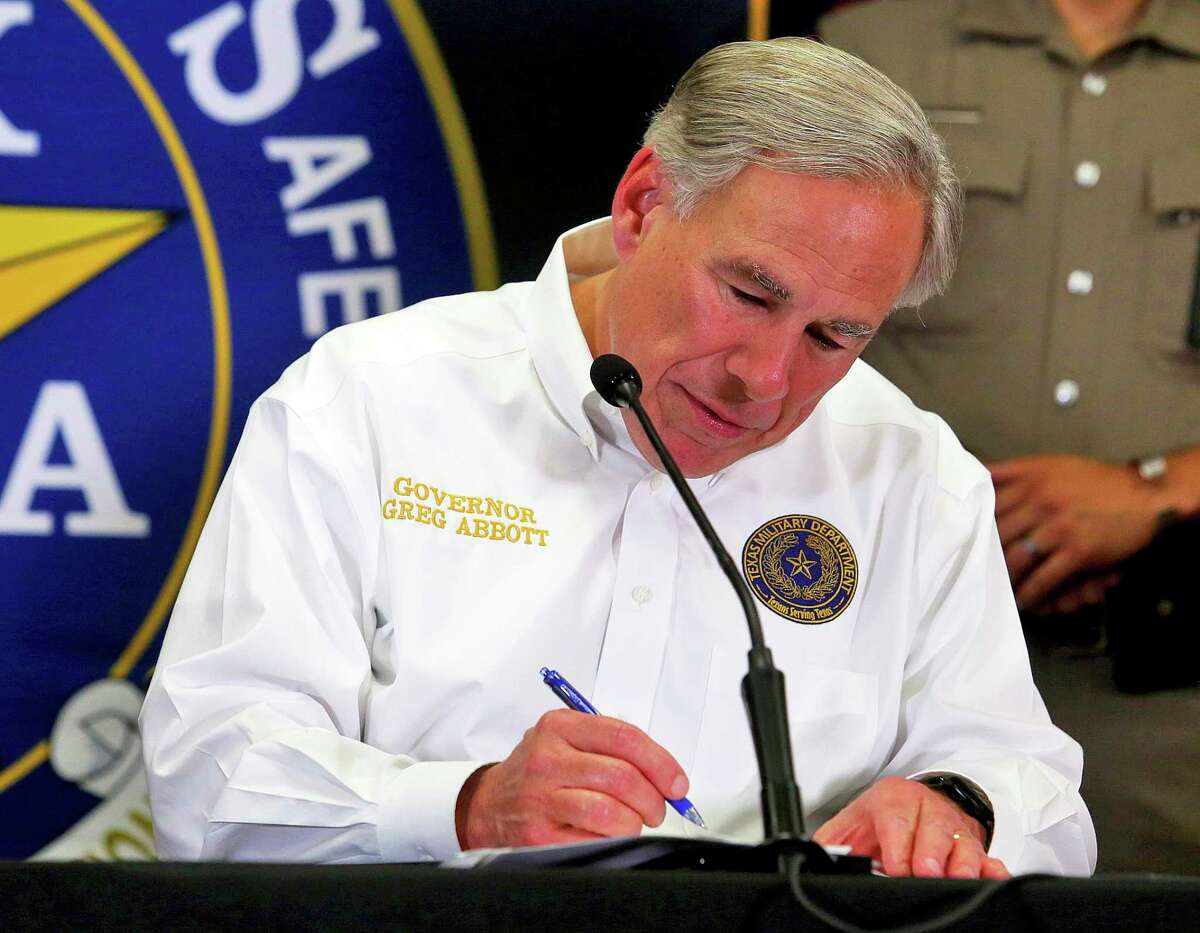 Texas Governor Greg Abbott signs a declaration during a press conference at the Texas Department of Public Safety Weslaco Regional Office on Wednesday, April 6, 2022, in Weslaco, Texas. Abbott says the state will provide migrants arriving at the U.S.-Mexico border bus charters to Washington, D.C. The move announced Wednesday amounts to a taunt at President Joe Biden and Congress over what the Republican governor calls a failure by the federal government to stop the flow of migrants coming to the southern border. (Joel Martinez/The Monitor via AP)