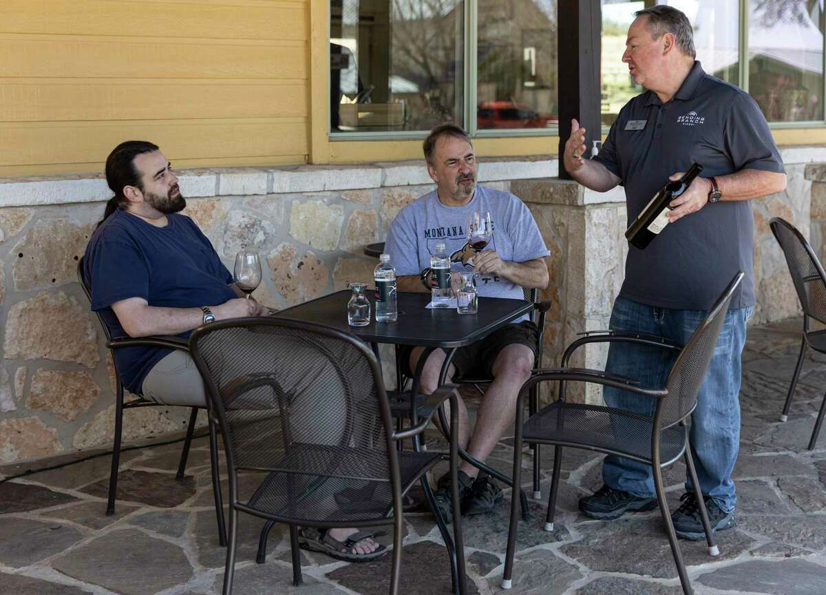 Lawrence and Marc Abrams talk to tasting room associate Will Thomas about the 2018 tannat at Bending Branch Winery.