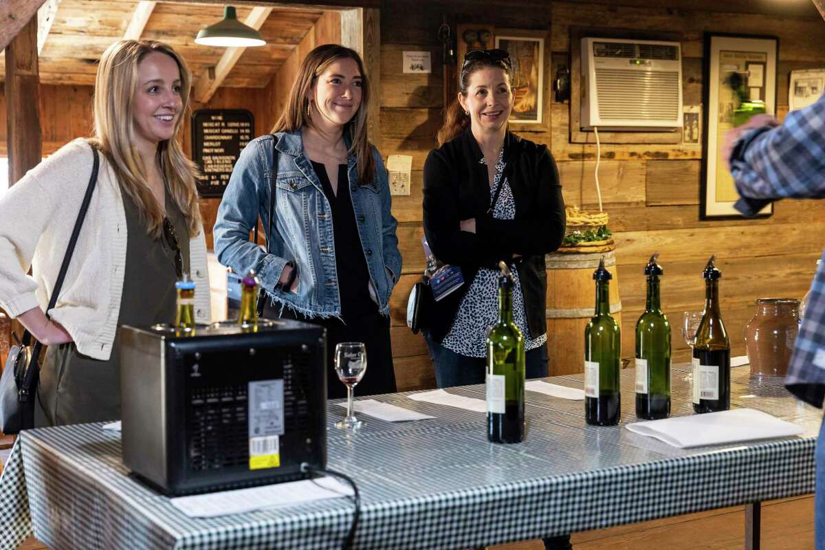 Meaghan Freiter (from left), Elise Damman and Wendy Mobley-Bukstein learn about the Sister Creek Vineyards wines from tasting room manager David Prejza.