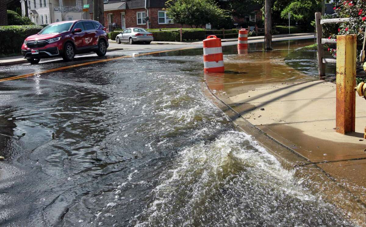 Water flows onto North Street partially flooding it as it is pumped out from an underground parking garage at The Wescott in Stamford, Conn., on Friday September 3, 2021. The remnants of Hurricane Ida pummeled the region on Tuesday causing severe flooding in many spots.