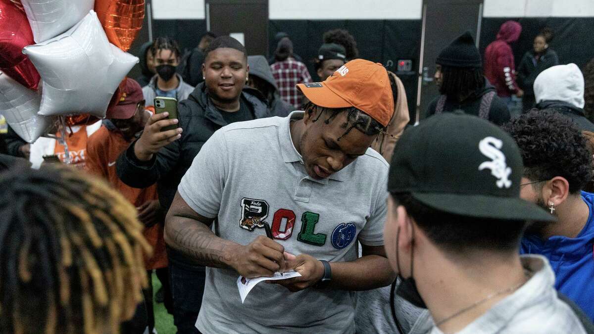 Arlington Bowie High School offensive lineman Devon Campbell signs his autograph on a photo at Arlington Bowie High School’s Multipurpose Activity Center in Arlington on Wednesday, February 2, 2022. Campbell announced at the signing he will play at The University of Texas.(Rebecca Slezak / Staff Photographer)