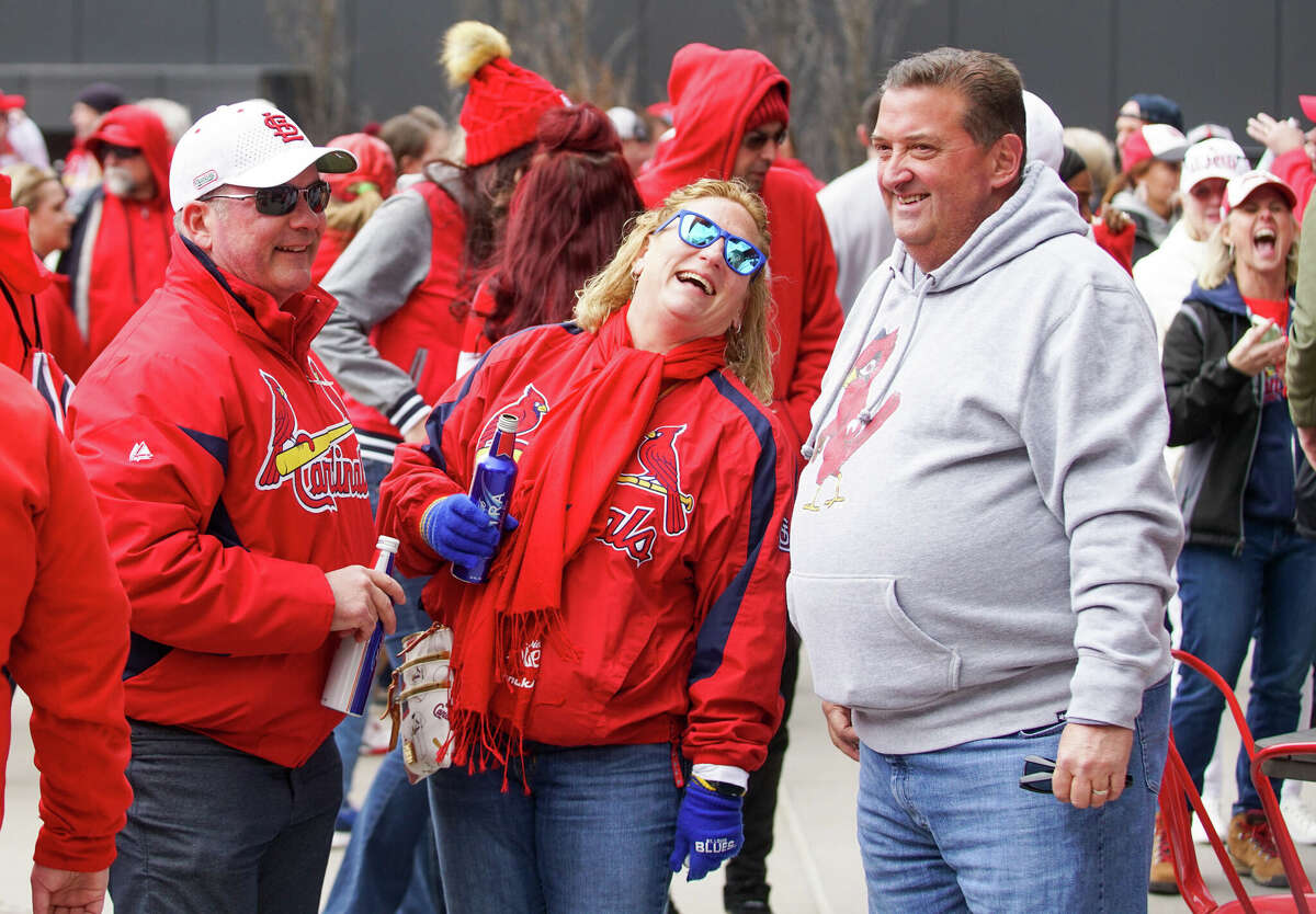 Gerard Fischer (right), his wife Beth Fischer and friend Dave Bamper celebrate Opening Day among a happy sea of Cardinal fans Thursday at Ballpark Village. 