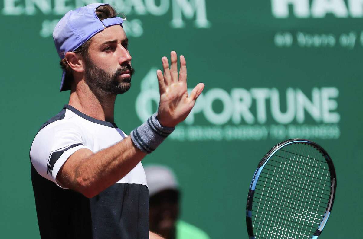 Jordan Thompson, AUS, holds up his hand after scoring off the net against Christian Garin, CHI, in the second round of the Fayez Sarofim & Co. U.S. Men’s Clay Court Championship at River Oaks Country Club in Houston on Thursday, April 7, 2022.
