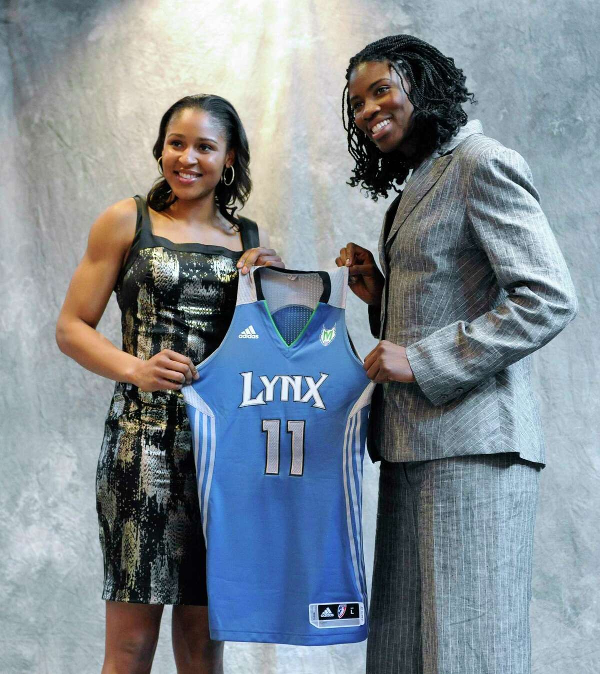 Connecticut's Maya Moore, left, and Xavier's Amber Harris, right, hold up a Minnesota Lynx jersey after being picked by the team in the WNBA basketball draft in Bristol, Conn., Monday, April 11, 2011. (AP Photo/Jessica Hill)