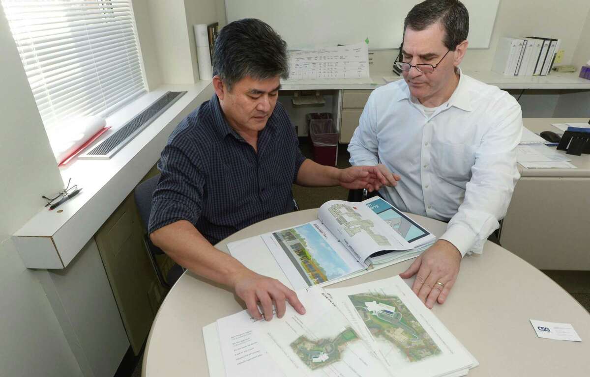 FILE PHOTO: Norwalk Building and Facilities Manager, Alan Lo, left, and Jim Giuliano, president of Construction Solutions Group, go over renderings of the South Norwalk school in 2018.