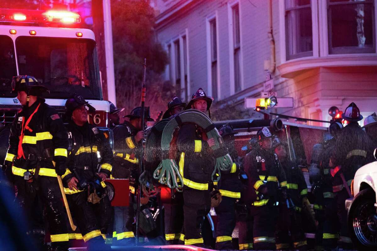 Firefighters at the scene of a three-alarm fire that broke out in a residential building near Duboce Triangle in San Francisco, Calif.