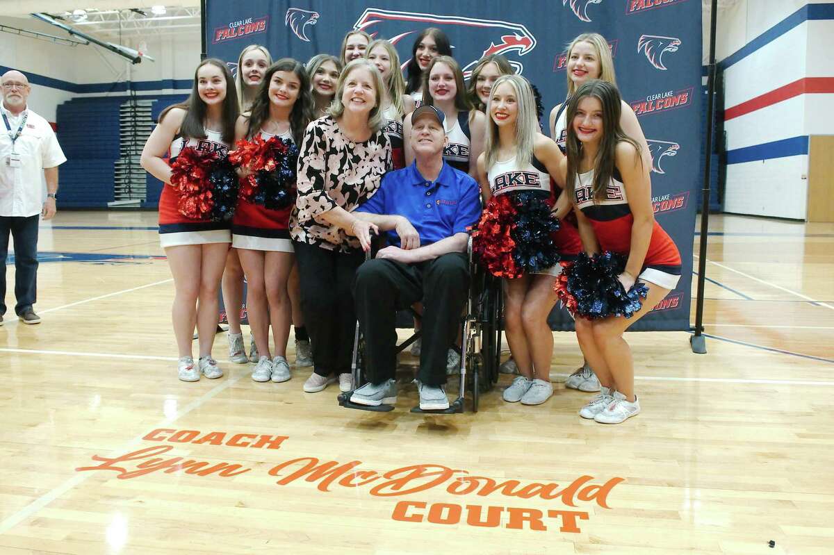 Former Clear Lake High School basketball coach Lynn McDonald and his wife Amy pose for photos with the Clear Lake High School cheerleaders during a ceremony naming the Clear Lake High School basketball court in his honor on April 7.