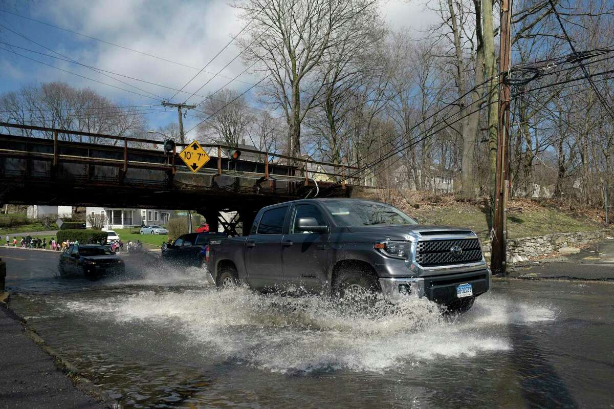 A pickup truck drives through the water under the rail bridge on West Street in Danbury on Friday. The National Weather Service forecast the Still River river to rise above flood stage in the morning, then return to below flood stage in the afternoon. Friday, April 8, 2022, Danbury, Conn.