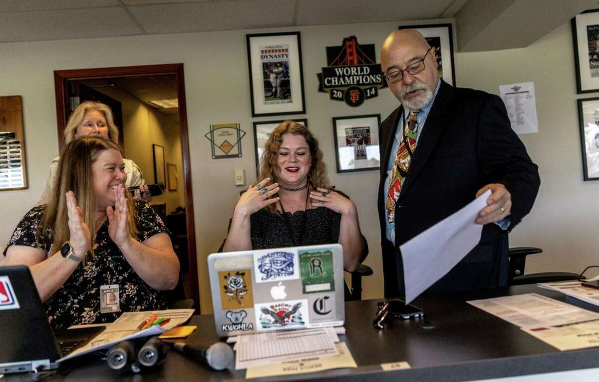 Alexandra Irving, the official scorer for the home MLB Opening Day baseball game between the San Francisco Giants and Miami Marlins, center, reacts after taking the scorer’s seat in the press box at Oracle Park in San Francisco, Calif. Friday, April 8, 2022. A native of Santa Clara, Irving, 32, is one of the first four women to score an Opening Day game in Major League Baseball this year.