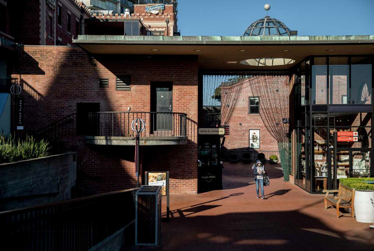 A woman walks through Ghirardelli Square in 2019. The historic San Francisco development is fully leased.