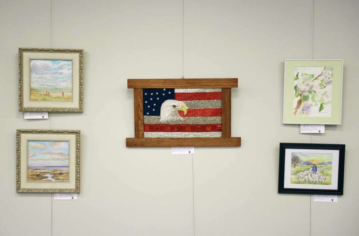 Vivien Ponniah's mixed media piece "Regal Eagle in +/- 20,000 Beads," center, is displayed at the Art Society of Old Greenwich's Members Spring Exhibit and Art Sale at the Greenwich Botanical Center in the Cos Cob section of Greenwich, Conn. Thursday, April 7, 2022. Dozens of pieces across a variety of mediums are displayed and for sale in the Botanical Center's auditorium. The opening reception will be held Saturday, April 9 at 4 p.m. and work will be displayed through May 26.