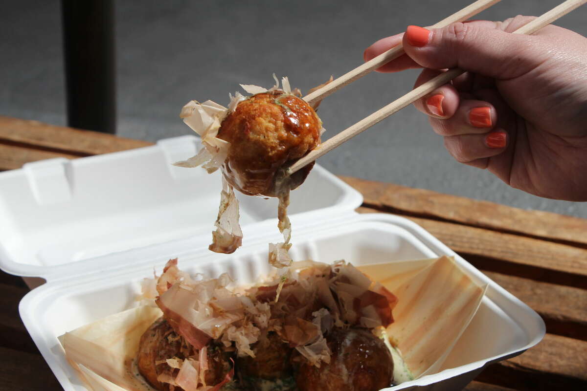 Takoyaki, deep-fried rounds stuffed with savory octopus meat, are one street food item offered during the Northern California Cherry Blossom Festival. 