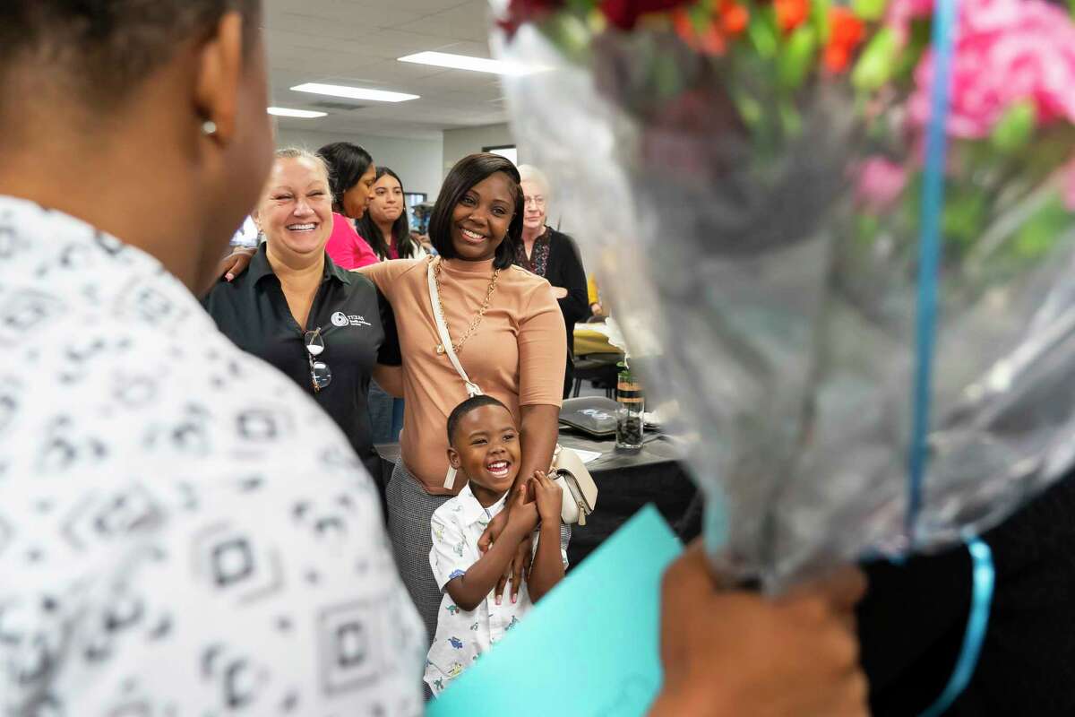 Friends and family crowd around Creshia Lewis and her three-year-old son as they take a picture with HHSC supervisor Gail Cox after a graduation ceremony celebrating five former foster youth who completed a work training program, Friday, April 8, 2022, at The HAY Center in Houston. Cox will serve as Lewis’s supervisor at Lewis’s new job. “This program is going to help me and my son tremendously. We won’t have to struggle anymore,” said Lewis as her eyes filled with tears and she collected her thoughts at the podium. “I can finally say I’m free from stress. I’m free. I really am. I’m free.” After completing a seven-week program, the participants will now start their full-time jobs as a Texas Works Advisor with the state Health and Human Services Commission.