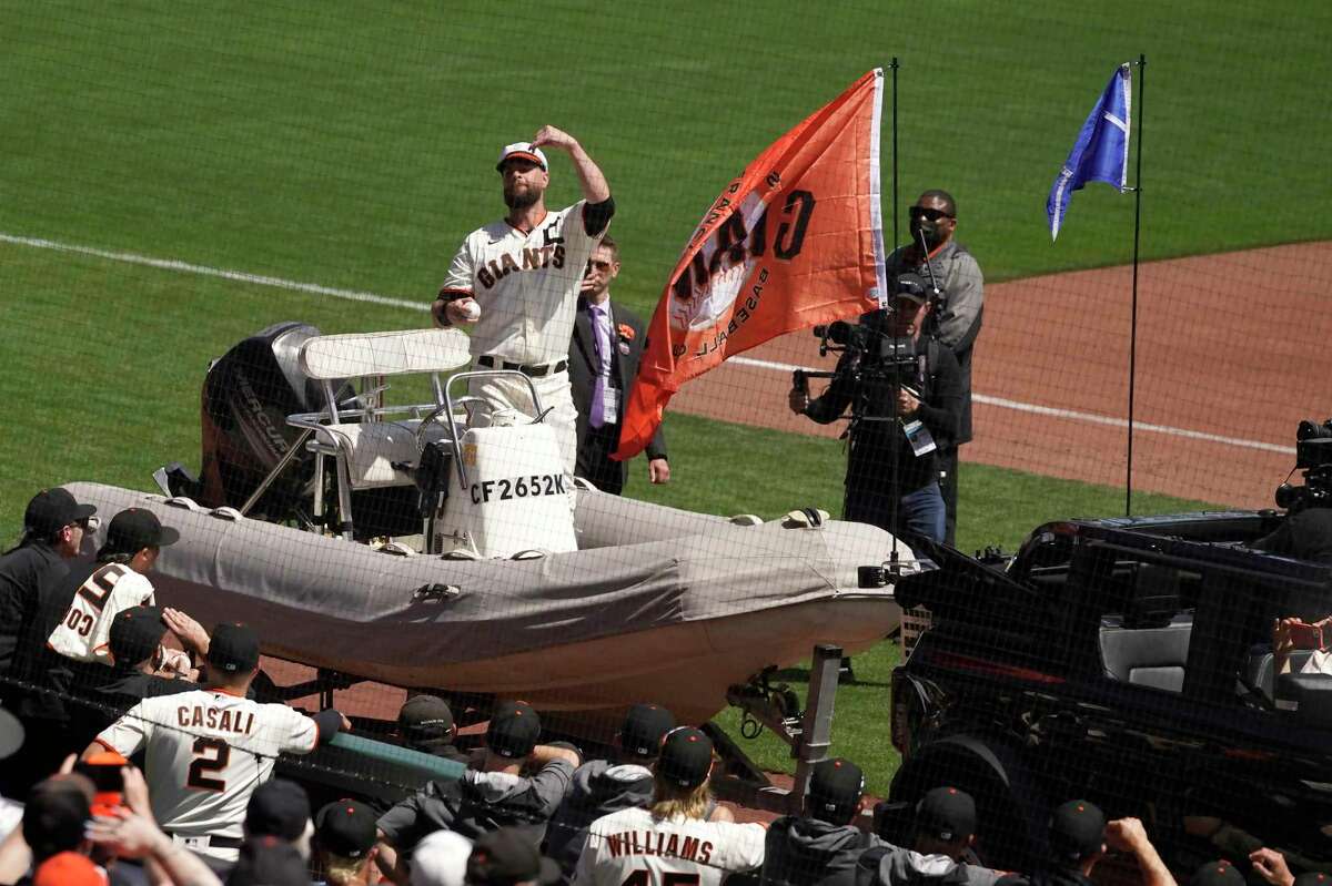 San Francisco Giants first baseman Brandon Belt is driven onto the field on a boat to throw the ceremonial first pitch before a baseball game against the Miami Marlins in San Francisco, Friday, April 8, 2022. (AP Photo/Eric Risberg)