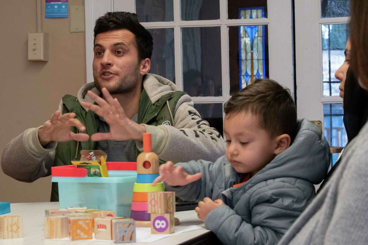 Abdul Hameed Danesh, left, his wife and child Abubaker Danesh, 18 mos., are seen in a meeting on Friday, Feb. 18, 2022 in Latham N.Y. The Afghan family got resettled on Siena's campus through the Every Campus a Refuge program.