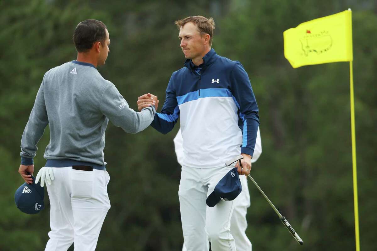 Xander Schauffele, left, and Jordan Spieth shake hands on the 18th green after finishing their round during the second round of the Masters at Augusta National Golf Club.
