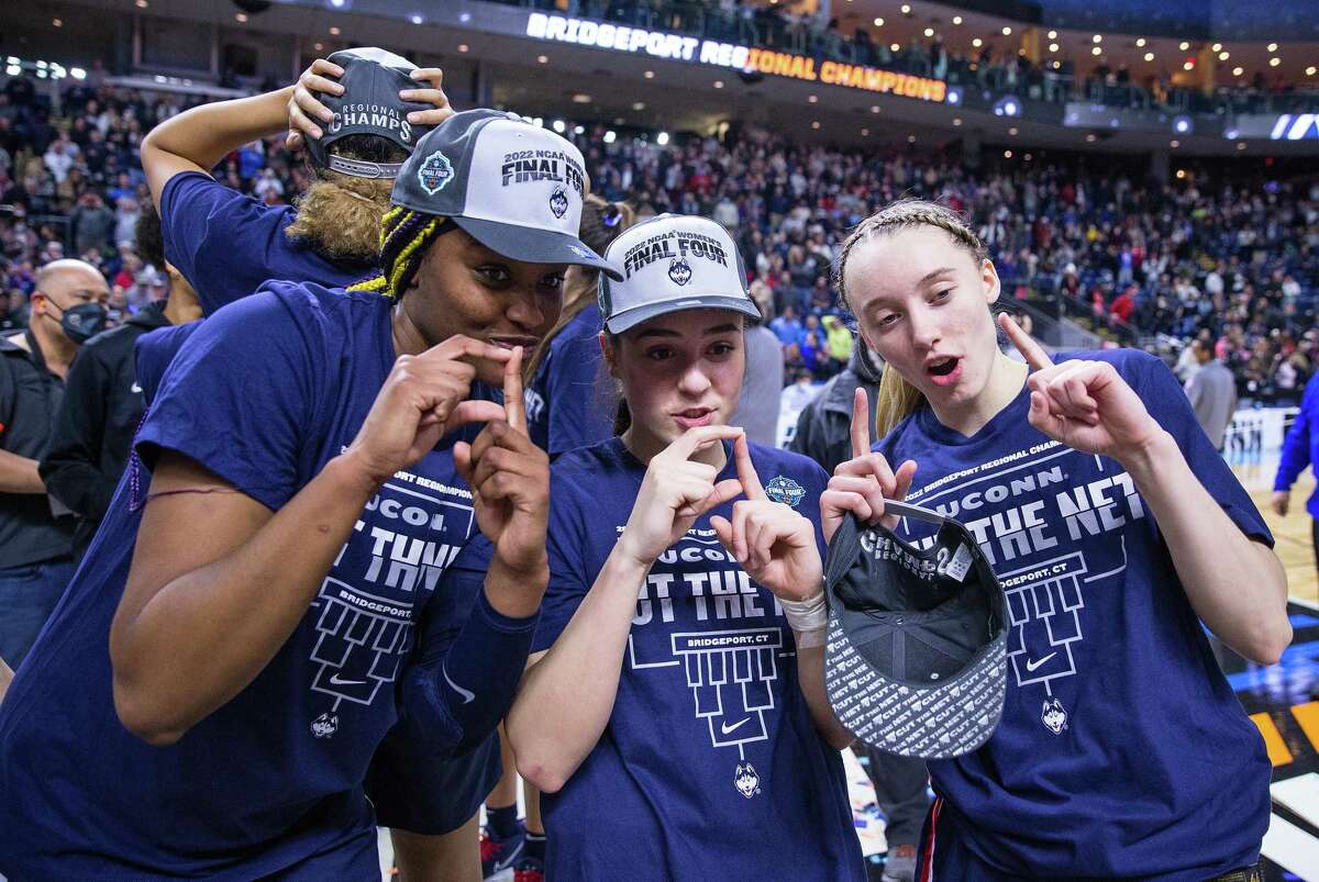 UConn Huskies forward Aaliyah Edwards (3), guard Nika Muhl (10) and guard Paige Bueckers (5) celebrate after defeating the NC State Wolfpack to become Regional Champions during the Elite Eight of the Women's Div I NCAA Basketball Championship on March 28, at Total Mortgage Arena in Bridgeport.
