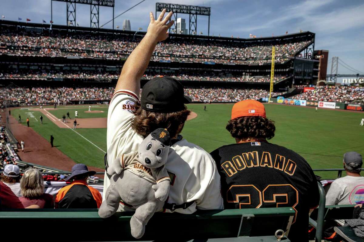 Wearing a Lou the seal backpack, Ayden Welch, of Concord, waves to a friend from the right field bleachers during a MLB Opening Day game between the San Francisco Giants and the Miami Marlins at Oracle Park in San Francisco, Calif. Friday, April 8, 2022.