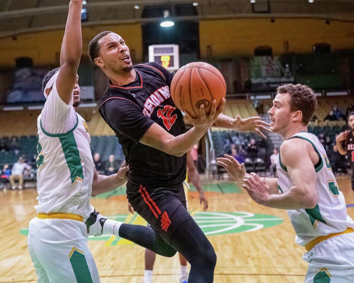 Reading Rebels forward Trenity Burdine drives to the basket Albany Patroons center Jared Sam and guard JC Show during a The Basketball League game at The Armory in Albany, NY, on Friday, April 8, 2022. (Jim Franco/Special to the Times Union)